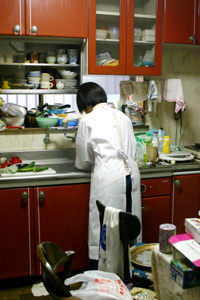 利用者さんのお食事の支度をする田久保さん。